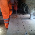 David Millard using a SDS plus drill with auger drill bit, to drill holes to screw or bolt down the vertical pulleys (for signal wire/chain) or vertical cranks (for point rodding).