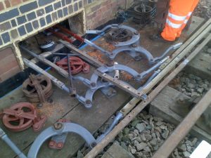 Cranks for lever 13 & 14 installed. Note the triple pulley with the chain on the top wheel that is now connected to Signal BG4. The bricked up lead out box reduces draughts for the signaller. The use of water pipe as a chain/wire conduit reduces the draughts and the chance of animals entering the box.