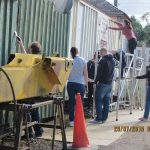 Nationwide Building Society volunteers cleaning the flaking and faded paint off the containers near the main entrance to the railway. Note how pale the container on the right looks, the biscuit paint has faded quite a lot. Photo: Grahame Every