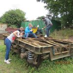 Nationwide Building Society volunteers scraping and cleaning off years of (rail) road dirt from the bogie frames and attached equipment. Photo: Graham Every