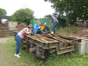 Nationwide Building Society volunteers scraping and cleaning off years of (rail) road dirt from the bogie frames and attached equipment. Photo: Graham Every