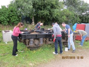 The first cleaned up B5 bogie is repainted using black chlorinated rubber paint, by Nationwide Building Society volunteers on 29th July 2015. Photo: Grahame Every