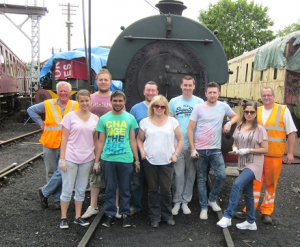 Nationwide Building Society staff and N&LR Volunteer Working Members Grahame Every and David Millard stand in front of Peckett 2105 on 15th July 2015