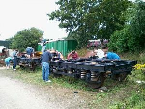 On 29th July 2015 Nationwide Building Society volunteers alongside Volunteer Working Members Grahame Every and David Millard, use quick drying chlorinated rubber paint on two BR B5 bogies that will be used under the BR Mark 2 coaches. Photo: David Millard