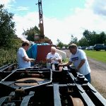 Nationwide Building Society volunteers painting a bogie, ready for the N&LR engineers to install it under one of the coaches. Photo: David Millard