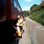 Nationwide Building Society volunteers, Rob, Vicky, Helen and Paul paint the B4 bogies of 5174 with black chlorinated rubber paint. Photo: D.Millard