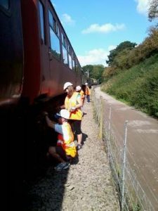Nationwide Building Society volunteers, Rob, Vicky, Helen and Paul paint the B4 bogies of 5174 with black chlorinated rubber paint. Photo: D.Millard