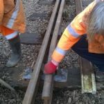 With screws put back in and the new check rail installed, Ian Nicholls supervises as David Millard backfills the ballast and inspects the new track work. Photo: Graham Peacock