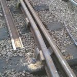 View of a completed running line point check rail on the running/main line side of the point. New CCL chair nearest, with new wooden keys to keep the rail firmly in place. Note the improved splayed end and compare against the old ones in step 2. We now have a decent check rail with no side wear on the head, with a more gradual lead in over the correct length, and properly seated in chairs and held firm. The lead in now has an initial flangeway gap of 3 ½ inches and the flangeway gap is now 1 ¾ inches along the parallel section and opposite the crossing nose on the point. It looks much better than the old one. Photo: Graham Peacock