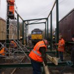 With all of the uprights in place along with two of the roof girders; the infrastructure team prepare to install one of the outer roof beams on 18 Feb 2018. Photo Credit: Tim Casentieri
